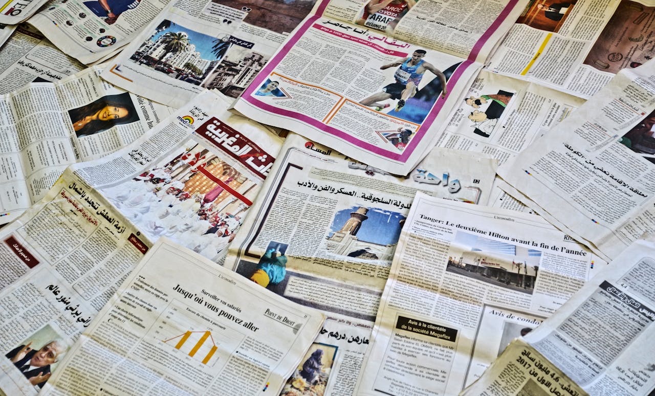 Close-up view of various newspapers laid out, showcasing diverse headlines and articles.